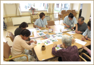 入居者が講師と一緒にテーブルでアート活動・創作レクをしている様子