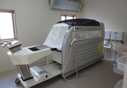 介護施設の機能訓練室に設置された医療用機器。リハビリテーション機器が配置されている。